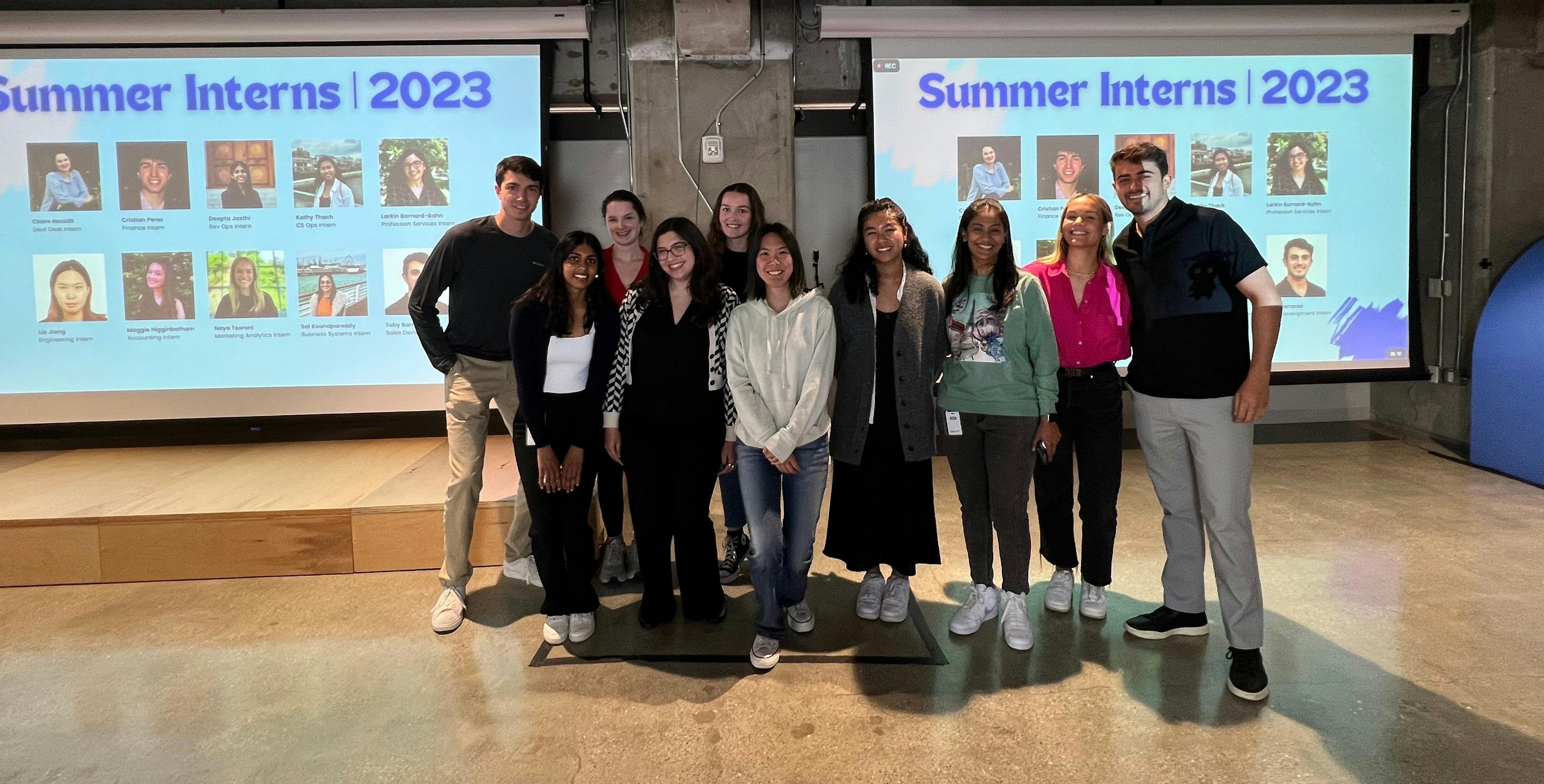 Lia Jiang standing amongst her peers in front of a slide showcasing the summers interns